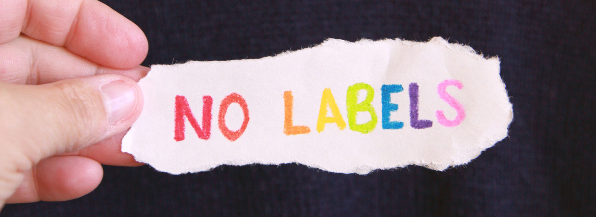 Mano de persona tomando un papel que dice 'No Labels'